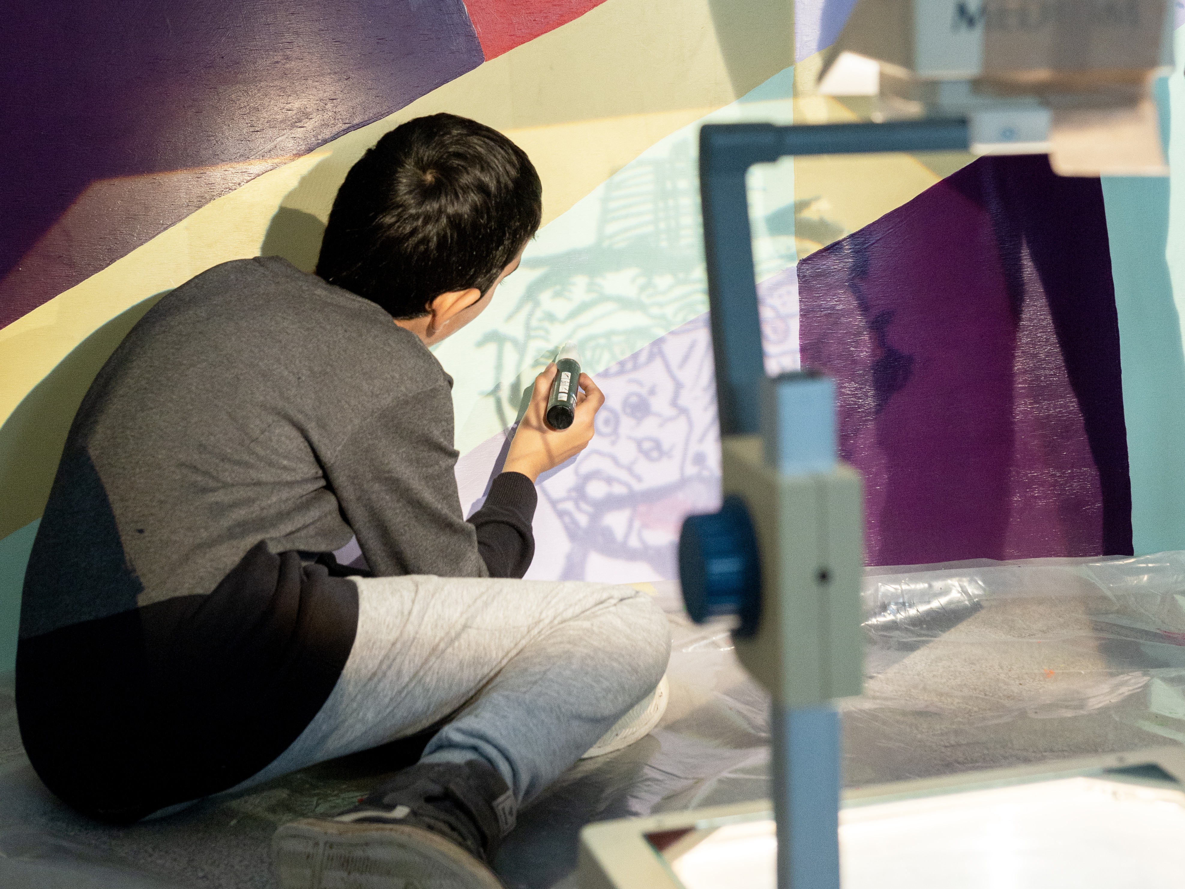 En dreng tegner på et værk med en tusch