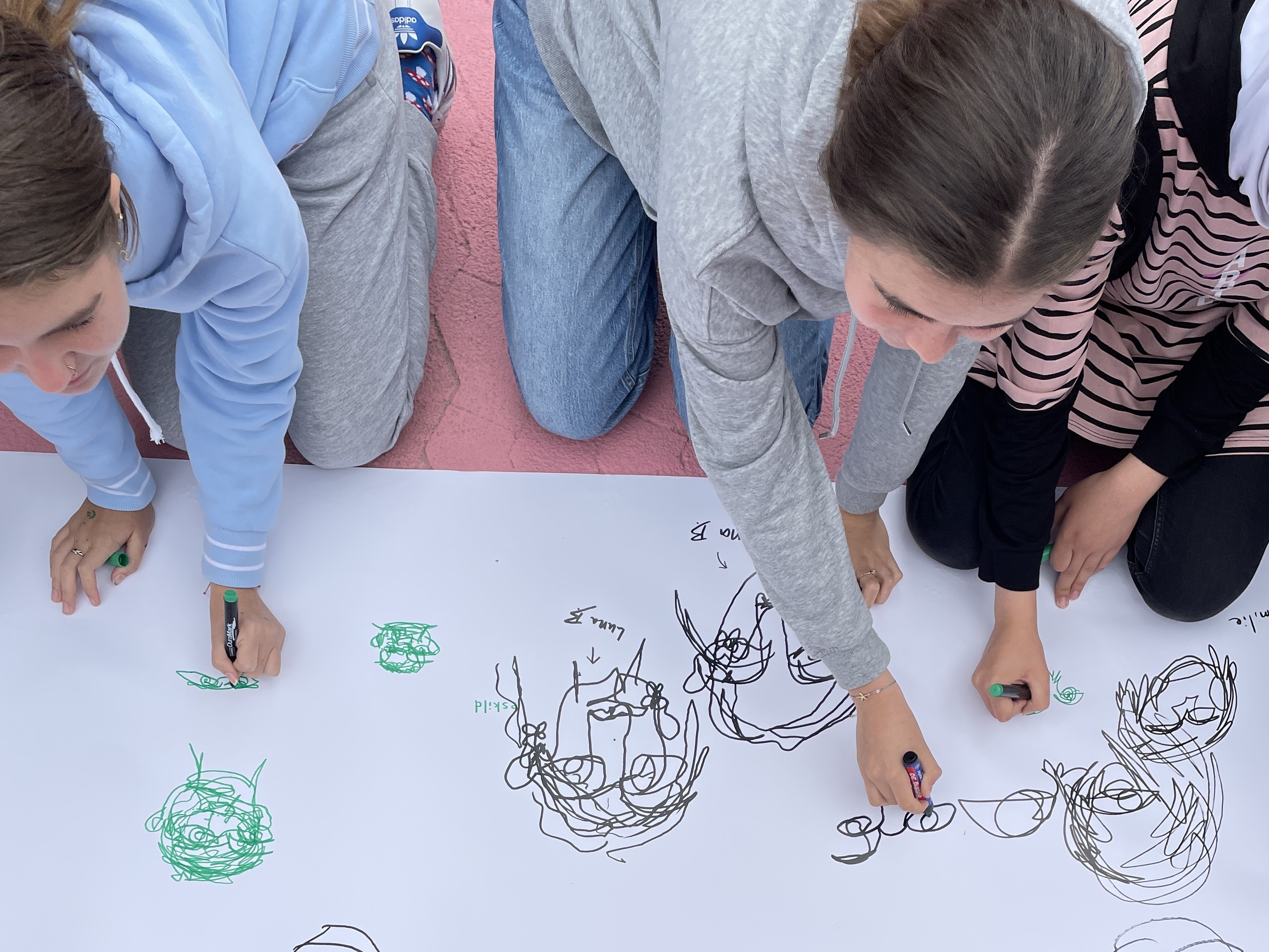 To piger kreerer en fælles tegning