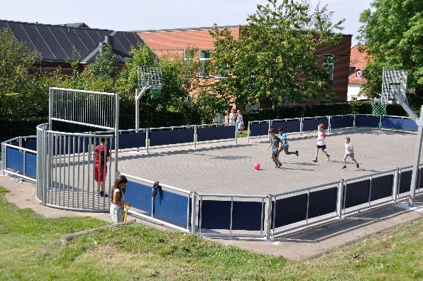 Billedet viser en gruppe SFO børn, der spiller fodbold på fodboldbanen ved afdeling Kildegade