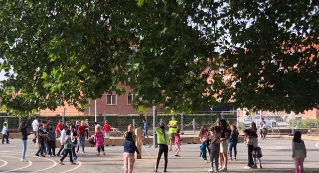 Billedet viser skolegården på Lindvigsvej, der er fyldt med legende og glade børn