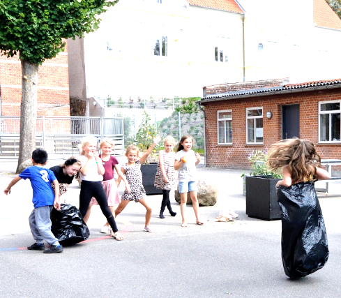 Billedet viser børn fra SFO'en på afdeling Kildegade, der er i gang med et sækkeløb ude i skolegården